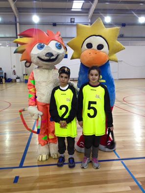 Foto dos dois jovens da Íris Inclusiva junto das mascotes da iniciativa