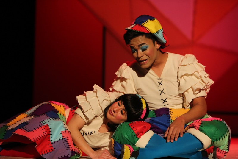 Imagem de um momento do espetculo em que surgem em palco dois atores, representando o papel de bonecos