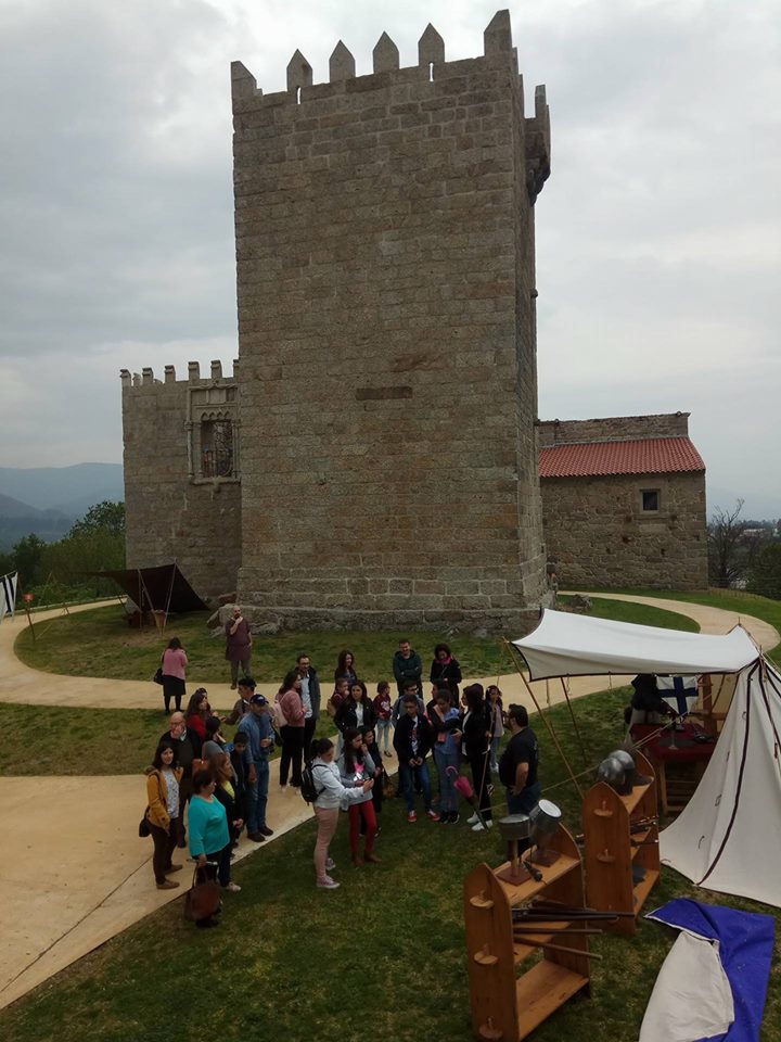 Vista geral, retirada de um ponto superior, do grupo de participantes, reunidos no exterior do Paço, vendo-se a torre do monumento ao fundo da imagem
