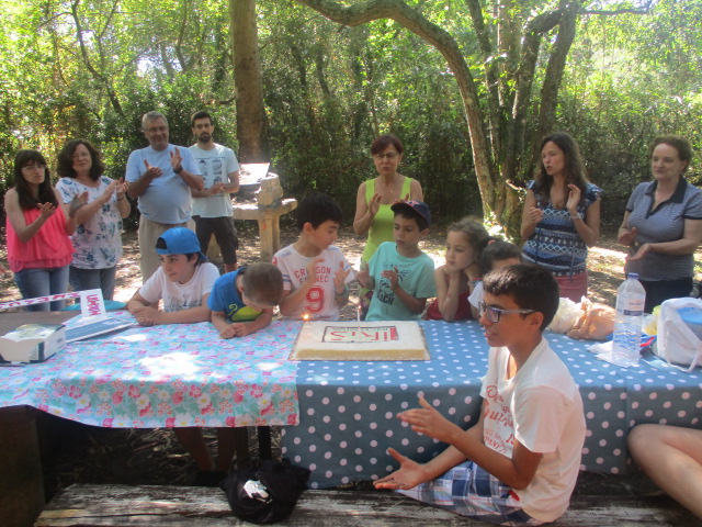 Participantes no piquenique a cantar os parabns  ris junto ao bolo do 8. aniversrio