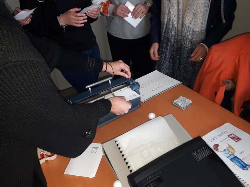 Vista geral do grupo de formandas utilizando uma máquina Braille para escreverem os seus nomes