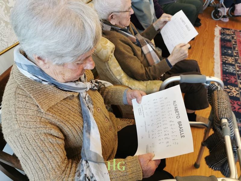 Dois residentes que participaram na ação explorando o alfabeto Braille