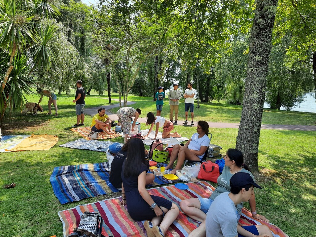 Participantes na atividade dispostos no relvado do parque