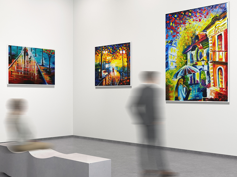 Espaço de exposição, com três pinturas visíveis sobre paredes brancas