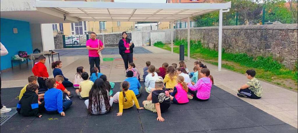 Alunos sentados no recreio escolar enquanto a equipa apresenta a atividade