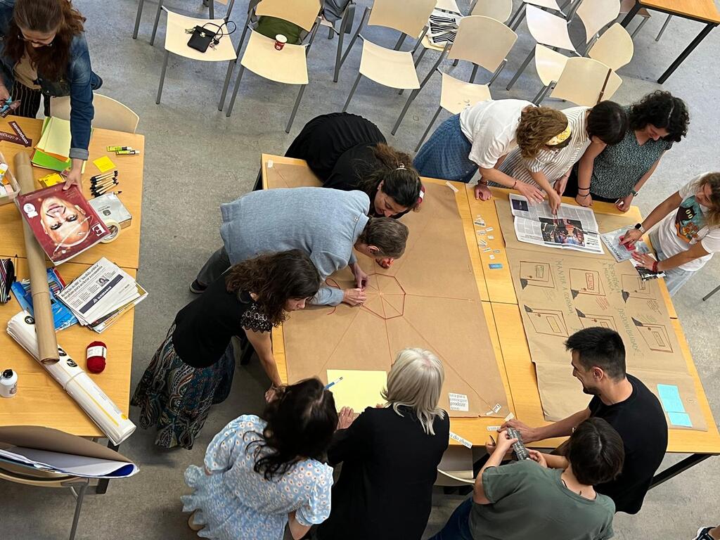 Grupo de participantes em volta de uma mesa, durante o exercício de cartografia social