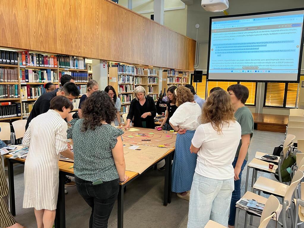 Grupo de participantes em volta de uma mesa, durante o exercício de cartografia social