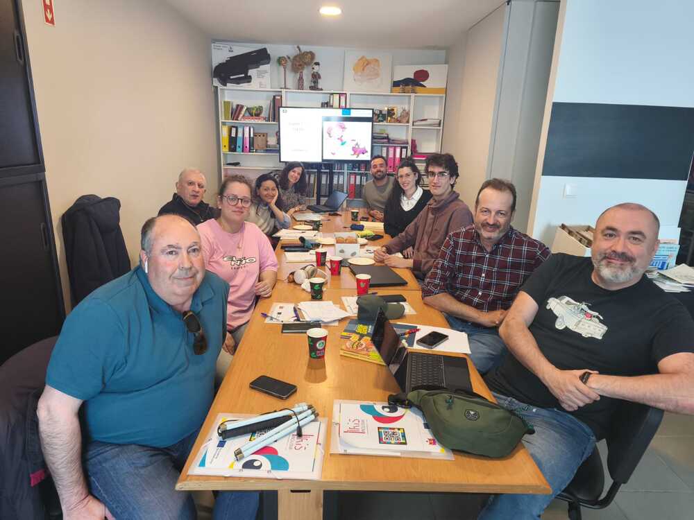 Participantes na reunião à volta de uma mesa de trabalho